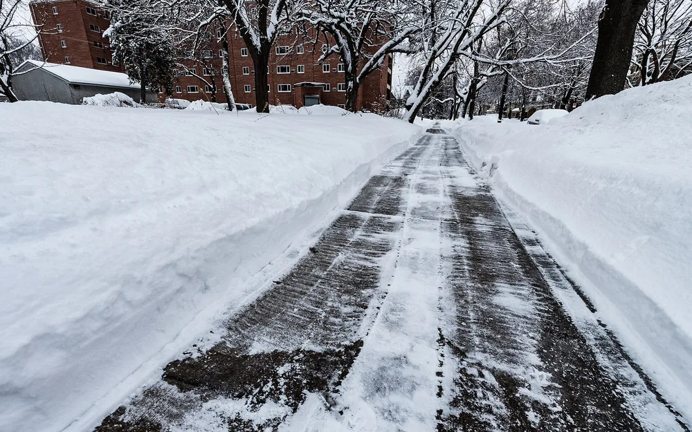 Freigeräumter Weg zwischen hohen Schneewällen